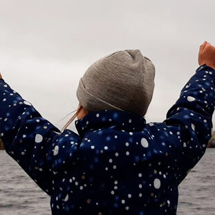 Ympäristökasvatuksen uutiskirjeen kuvituskuvana on iloinen lapsi järven äärellä.